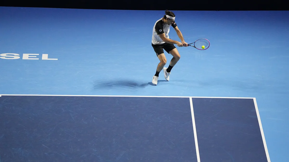 Taylor Fritz hitting a backhand indoors at the Swiss Indoors Basel in 2025